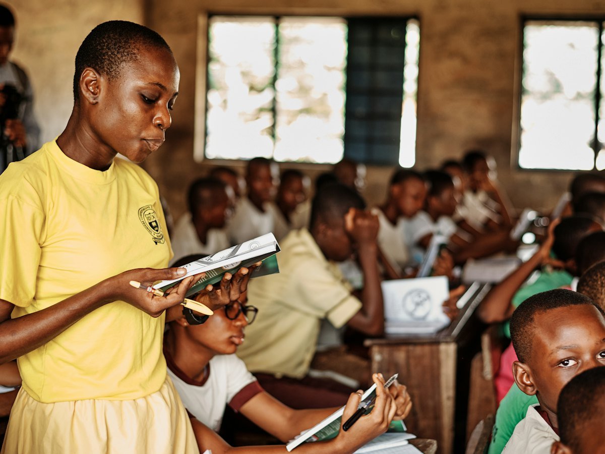 A teacher reading with her pupils in a basic school classroom